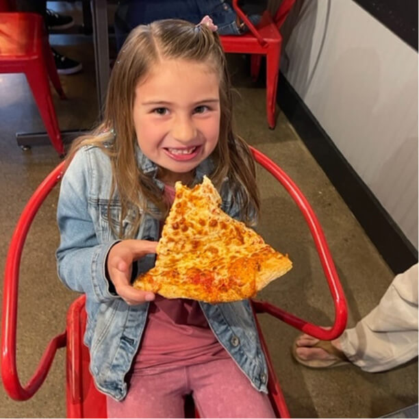 Child eating a large slice of pizza